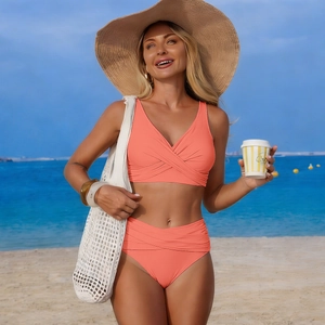 Close-up of coral high-waisted bikini set with crossover V-neck and ruched details