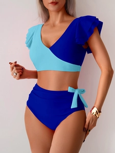 Detail of high waist bikini bottoms with light blue bow tie and ruffled one-shoulder top