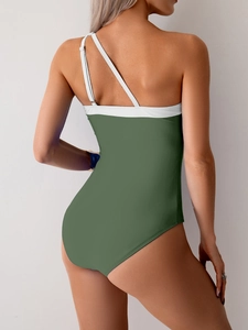 Detail view of olive green one-piece swimsuit featuring asymmetric white shoulder straps