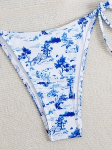 Detail of high-cut bikini bottoms featuring blue Toile de Jouy print and side tie strings