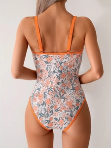 Detailed back view of floral one-piece swimsuit with orange straps and metallic buckle