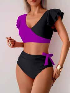 Detail of ruffle shoulder design and high-waisted bikini bottoms in purple and black colors