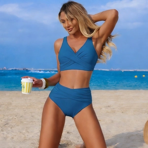 Detail of high waisted navy blue bikini bottoms with side ruched texture on sunny beach