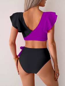 Detail of high waisted bikini with ruffled purple top and bow ties on the black bottoms