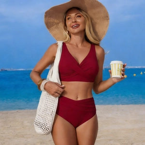 Detailed view of burgundy high-waisted bikini with tummy control ruched details and deep V neckline