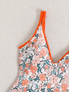 Close-up of orange-trimmed floral one-piece swimwear with vibrant flower patterns