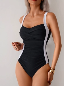 Detail view of monochrome one-piece swimsuit featuring elegant twist-knot bodice and ruching
