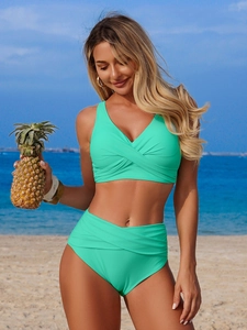 Chic mint green high waisted bikini set with deep V-neck cross ruched top on tropical beach