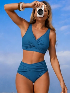Two-piece high-waisted bikini set in deep teal blue featuring a cross-neck V-neck design