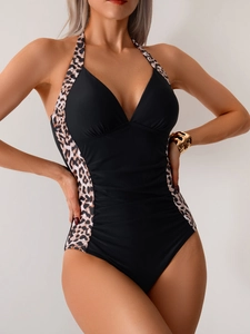 Detail of slimming one-piece swimsuit with deep V-neck, leopard print straps and ruched front