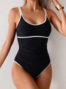 Detail view of one-piece swimsuit with black matte fabric and white stripe piping details