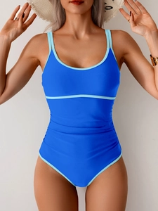 Detail of royal blue one-piece swimsuit featuring tummy control ruching and contrast piping
