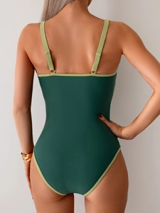 Detail of dark green one-piece swimsuit featuring an open back and adjustable straps