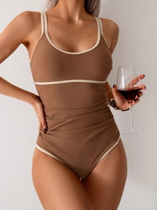 Brown one-piece swimsuit with white trim and tummy control ruching for vacation