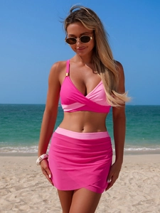 Detail of pink two-piece split swimsuit with criss-cross halter neck and ruched swim skirt