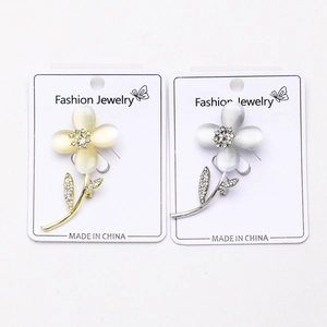 Détail de broches fleur avec pétales opale et zircon sur cartes de présentation bijoux