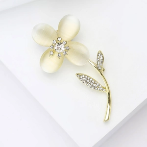 Détail macro d'une broche fleur en pierre œil de chat avec pétales dorés et zircon