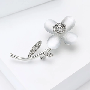 Détail d'une broche fleur avec pétales d'opale et zircons sur socle géométrique