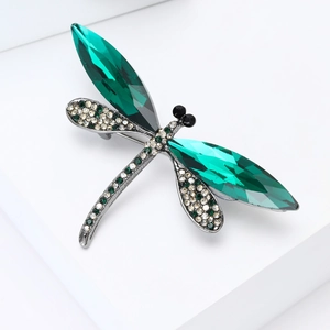 Detail of dragonfly brooch with emerald green teardrop crystals and silver metal base