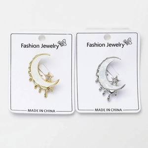 Détail de broches lune fondante avec incrustation en nacre et étoile en zircon sur carte