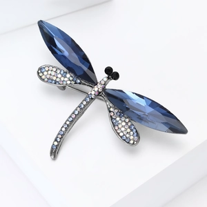 Detailed close-up of dragonfly brooch featuring faceted blue gems and colorful rhinestones