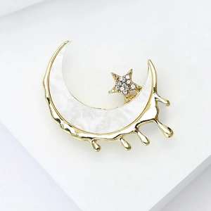 Détail de la broche croissant de lune dorée avec incrustation de nacre et strass étoilé