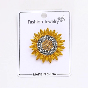 Détail d'une broche tournesol ornée de strass jaunes et noirs sur une carte