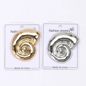 Polished snail shell alloy brooches in gold and silver finish on display card