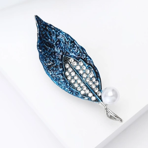 Makro-Detail der blauen Emaille-Blattbrosche mit Kristallbesatz und weißer Perle