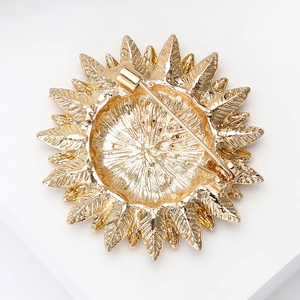 Vue détaillée du dos d'une broche tournesol dorée avec fermoir et texture en métal