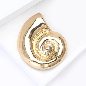 Macro shot of minimalist matte gold snail shell brooch with realistic spiral textures