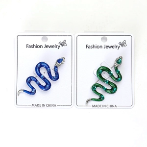 Gros plan détaillé des broches serpent vintage en forme de S avec des gemmes colorées