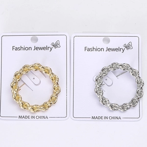 Detail of twisted round stud earrings in gold and silver finish with textured surface