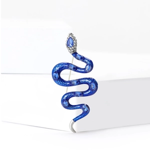 Détail macro d'une broche serpent en émail bleu avec saphir et tête argentée