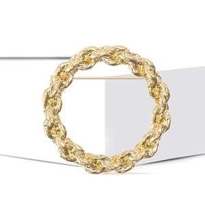 Vintage gold alloy round brooch with woven rope texture on white display block