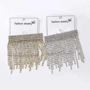 Detailed macro view of sparkling gold and silver rhinestone long tassel earrings on cards