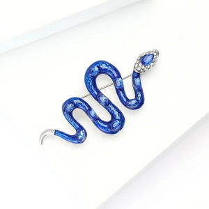Détail macro d'une broche serpent en émail bleu sertie de cristaux et argentée