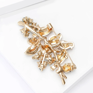 Close-up of the golden metal brooch back featuring detailed craftsmanship and safety pin clasp
