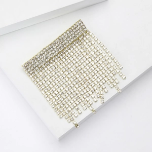 Detail of luxury rhinestone tassel brooch with shimmering crystals on white stairs