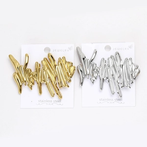 Close-up of gold and silver wave textured stainless steel brooches with liquid metal design