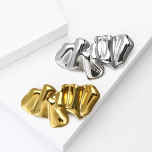 Detailed macro view of wavy textured metal brooches with polished gold and silver finish