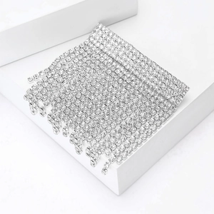 Detail of silver rhinestone fringe brooch with shimmering crystals on white stone