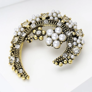 Détail de la broche vintage fleur et lune avec perles et strass sur fond blanc épuré