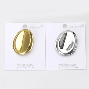 Close-up of oval stainless steel stud earrings in polished gold and silver finishes