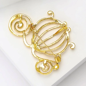 Detailed back view of the golden pumpkin carriage brooch showing hollow metal structure
