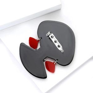 Broche artistique en acrylique style Comme des Garcons avec silhouette noire et cœurs