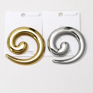 Macro detail of spiral snail design brooches in polished silver and gold stainless steel