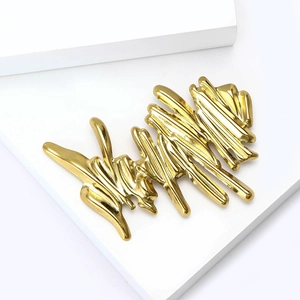 Macro shot of abstract fluid lava lines on a gold polished stainless steel brooch