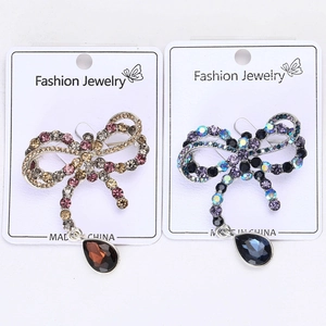 Close-up of bow brooches with colorful rhinestones and teardrop crystal pendants