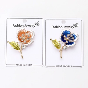 Detailed close-up of colorful flower brooches with enamel petals and sparkling rhinestones